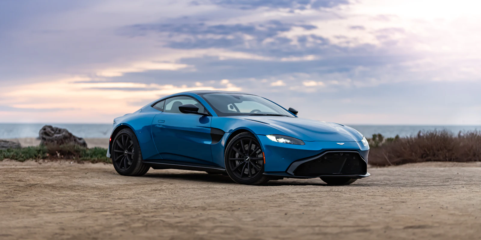 Blue Aston Martin Vantage by the coast